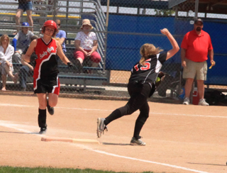 Kendall Schumacher fist pumps at first base after catching a throw at first for the final out of the championship game.