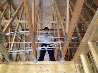 Ryan Hasselstrom, teacher, organizing all of the wiring and making the runs through the soon to be attic.