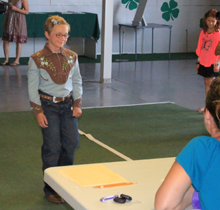 Molly Johnson, daughter of Doug and Misty Johnson models her vintage cowboy outfit Monday morning for the judges as others wait their turn in the Beginning modeling.
