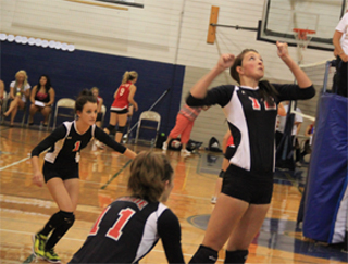 Tyler Workman shows concentration as she goes up for a spike at the Grangeville Jamboree. At left is Leah Holthaus and in front is Krystin Uhlenkott.