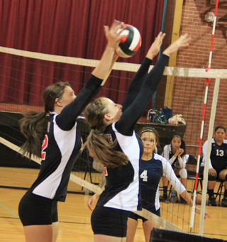 Tyler Workman blocks a Lapwai spike as she and Hailey Danly both go up for the block. Does closing your eyes help?