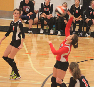 Stephanie Gimmeson goes for a back row kill in the Kendrick Tournament.  At left is Leah Holthaus and in the foreground is Krystin Uhlenkott.