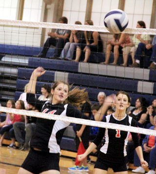 Shelby VonBargen and Leah Holthaus watch the ball come down on Kamiahs side of the net after Shelbys block.