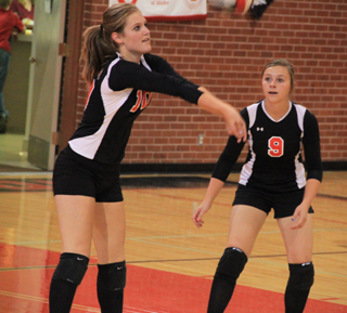Tanna Schlader makes a pass in the Genesee match as her cousin Brooke Schumacher, in her first action of the season, looks on.