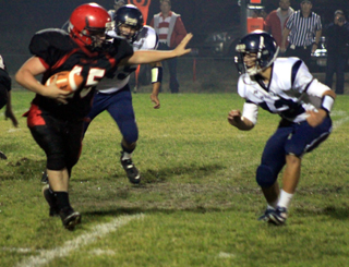 Garrett Schmidt strikes the classic Heisman Trophy pose as he looks to ward off a Lapwai defender on a running play.