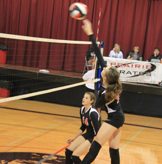Krystin Uhlenkott powers into the ball for a kill in the Highland match as Shelby VonBargen watches for a possible block.