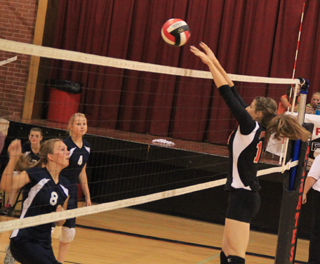 Prairies Shelby VonBargen blocks a spike from Summits Sarah Chmelik, 8. Also shown from Summit is Ashlee Stubbers, 4.