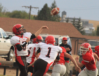 Marcus Higgins passes the ball against C.V. Shown blocking for him are Garrett Schmidt and Lucas Arnzen, 1.