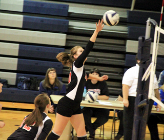 Tanna Schlader goes for a spike against Kamiah. In the foreground is Tyler Workman.