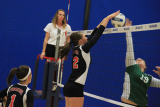 Tyler Workman wins a joust at the net with a Potlatch hitter at District. At left is Leah Holthaus.