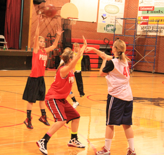 Kayla Schumacher tries to pass over a leaping Callie Mader as she is guarded by Taylor Heitman during a drill. Behind Heitman are Nicole Wemhoff and coach Lori Mader.