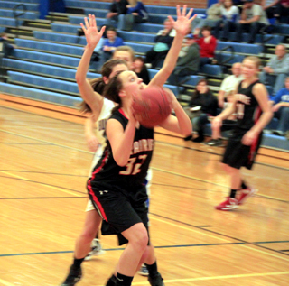 Taylor Heitman shoots against Genesee. In the background is Kayla Schumacher.