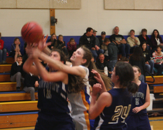 Megan Seubert appears to get fouled on a rebound as Megan Rehder, 24, and Rachael Frei watch.
