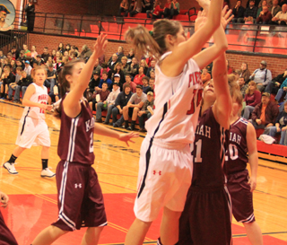 Shelby VonBargen puts a shot up against Kamiah. At left is Nicole Wemhoff.