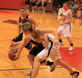 Tanna Schlader and a Kendrick player get their arms entangled as they go after a loose ball. At right is Brooke Schumacher.