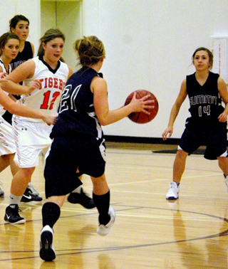 Abi Chmelik looks to pass to Rachel Waters, 14. At left is Megan Seubert. Photo by Rose Frei.