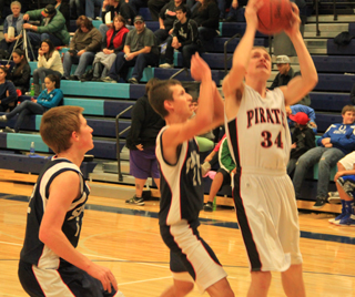 Lucas Arnzen goes for a shot against Summit with Michael Waters looking to time his jump just right for a block. At left is Summits Josh Lustig.