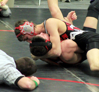 The referee gets a good look as Tayler Heitman is about to score a pin.