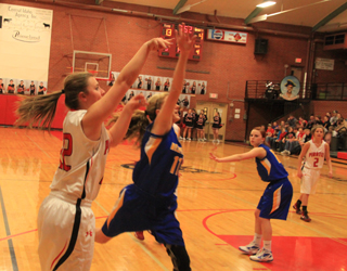 Brooke Schumacher gets a shot past a block attempt by Nezperce. At right is Callie Mader.