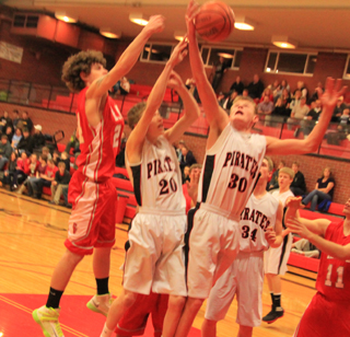 Jake Bruner snags an offensive rebound in the game against C.V. over teammate Dan Wemhoff. Lucas Arnzen is behind Bruner and Rhett Schlader can be seen in the background.