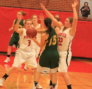 Keely Schmidt and Brooke Schumacher doubleteam the ballhandler in the Potlatch game. Tanna Schlader can be seen in the background.