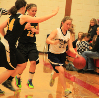 Summits Jolene Chmelik handles the ball as Highland defenders close in.