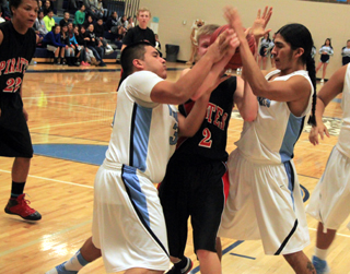 Rhett Schlader gets doubleteamed by Lapwai defenders. At left is Tyler Hankerson.
