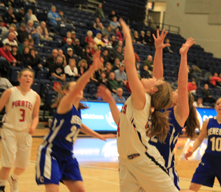 Tanna Schlader puts up a shot in the lane against Genesee at District. At left is Keely Schmidt.