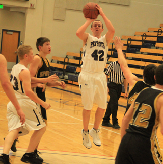Matthew Schwartz puts up an open jump shot against Timberline at District. At left is Nathan Beckman.