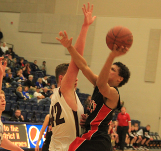Tyler Hankerson uses his right arm to ward off a block attempt as he shoots left-handed against Kamiah.