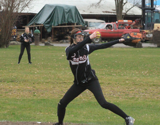 Pitcher Leah Holthaus looks rather intimidating this year as she has gone to wearing a mask to protect her face against batted balls. In the background is right fielder Kelsey Tidwell.