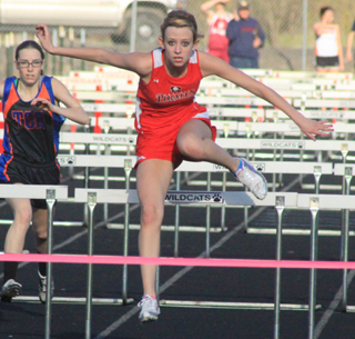 Brandi Gehring clears the last hurdle and is about to win her heat at the Border War meet.