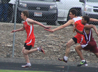 Gabe Angus stretches to hand off to Dylon Bruegeman in the 4x100 relay.