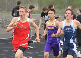 Peter Spencer passes a Grangeville runner on the final corner of the 1600 as he went on to win at the Wildcat Invitational last Friday.