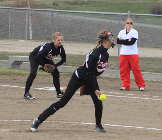 Leah Holthaus is about to release a pitch in the C.V. game. In the background is first baseman Kendall Schumacher. She came within 1 hitter of pitching a perfect game.