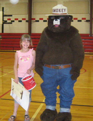 Katteri Duman, shown with Smokey, was the 1st place winner for the third grade in the National Garden Clubs Smokey the Bear/Woodsy Owl poster contest.