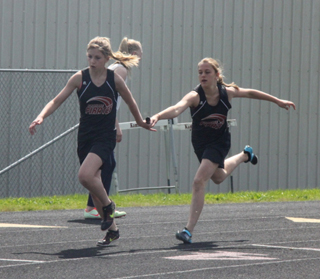 Chaye Uptmor receives the baton from Nicole Poxleitner in the medley relay.