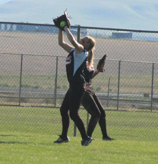 Kelsey Tidwell catches a fly ball against Genesee. She and Taylor Nuxoll, behind her, each had quite a few fly ball outs in the game.