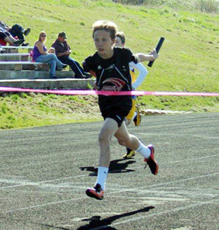 Sean Spencer about to break the tape first in a relay event.