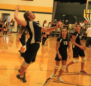 Summits Rachael Frei goes up for a spike as Rachel Waters and Megan Seubert look on.