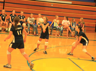 Rachel Waters makes a pass. At left is Kaitlyn Stubbers while at right is Megan Rehder.