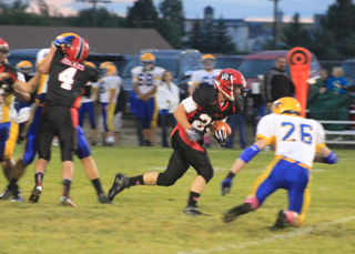 Calvin Hinkelman gains yardage against Salmon River. Blocking behind him is Isaiah Shears, #4.