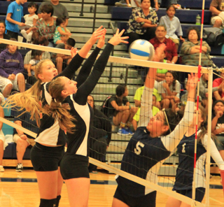 Kayla Schumacher and Hailey Danly put up a wall against this spike attempt at Lapwai.