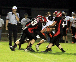 Prairie defenders Calvin Hinkelman, Matt Schwartz, right, and Casey Danly, in back, had a meeting at the quarterback, sacking him for a 9 yard loss.