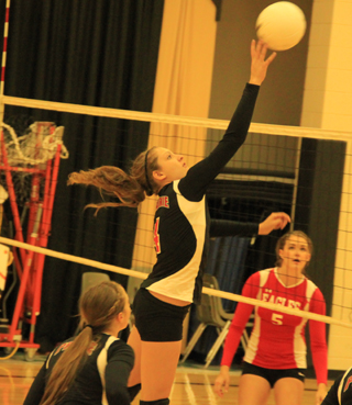 Shayla VonBargen tips the ball over agaisnt St. John-Endicott at the Border Battle. Also shown is Hailey Danly.