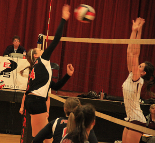 Shayla VonBargen hits a spike against Kamiah. Also shown from left are Hailey Danly and Natasha Gimmeson.