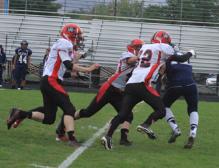Matt Schwartz and Casey Danly engulf the Lapwai quarterback for a big loss. Trailing into the play are Isaiah Shears and Lucas Arnzen.