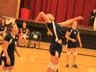 Summits Alli Hale goes for a spike against Highland as Rachael Frei, 9, and Megan Rehder, 7, watch.