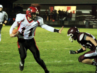 Jake Bruner strikes a Heisman trophy pose as he stiffarms a Kamiah defender on a running play.