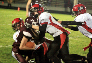 Matt Schwartz and Rhett Schlader tackle a Kamiah runner for a loss as another Pirate defender comes into the play.